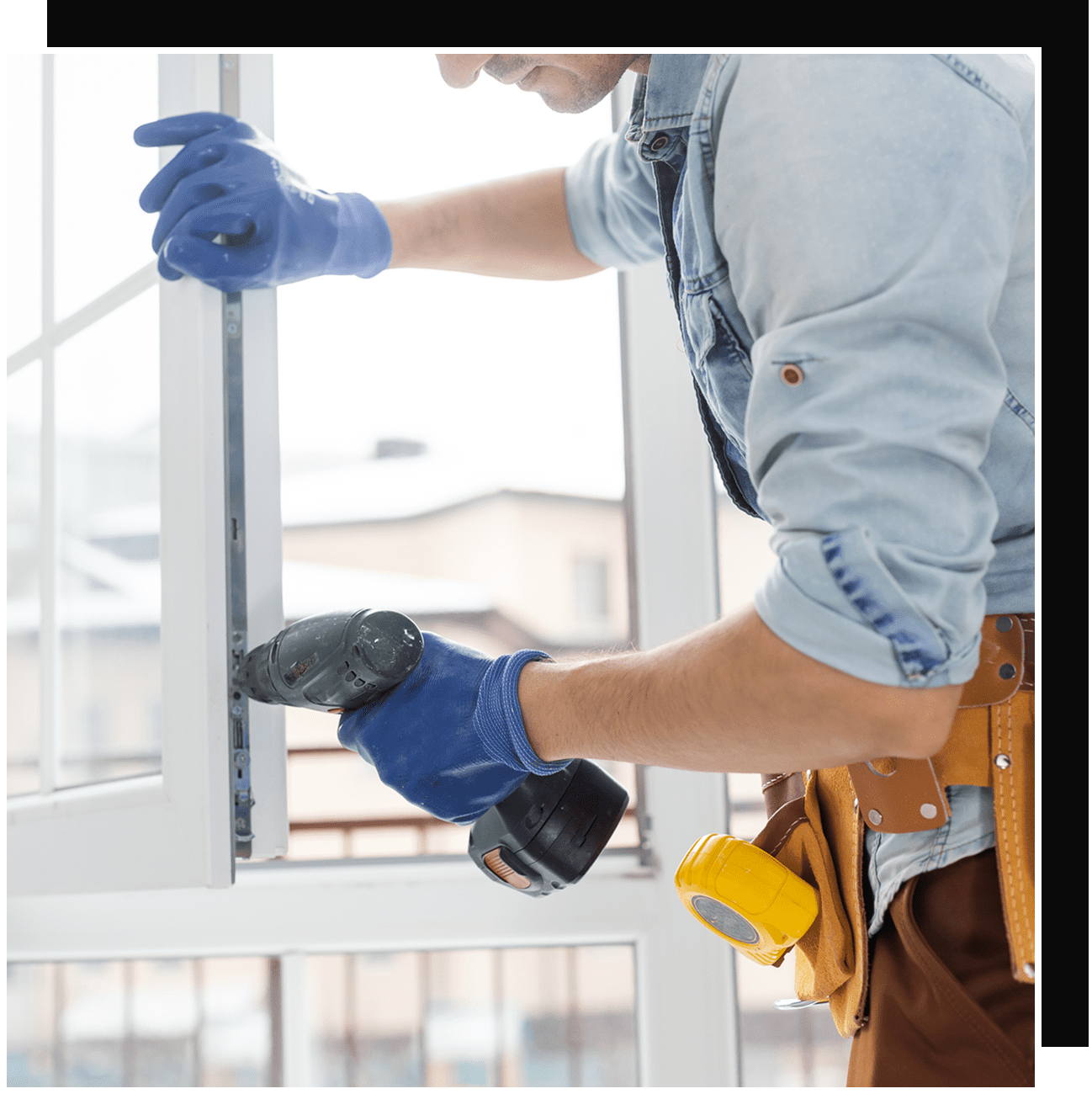 Worker installing window with drill