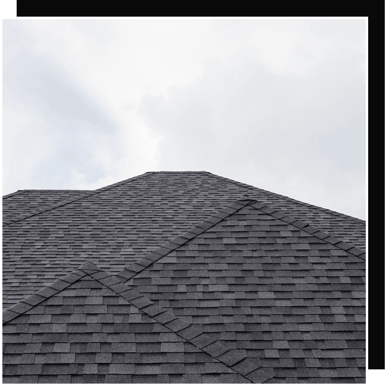 Gray asphalt shingle roof under cloudy sky