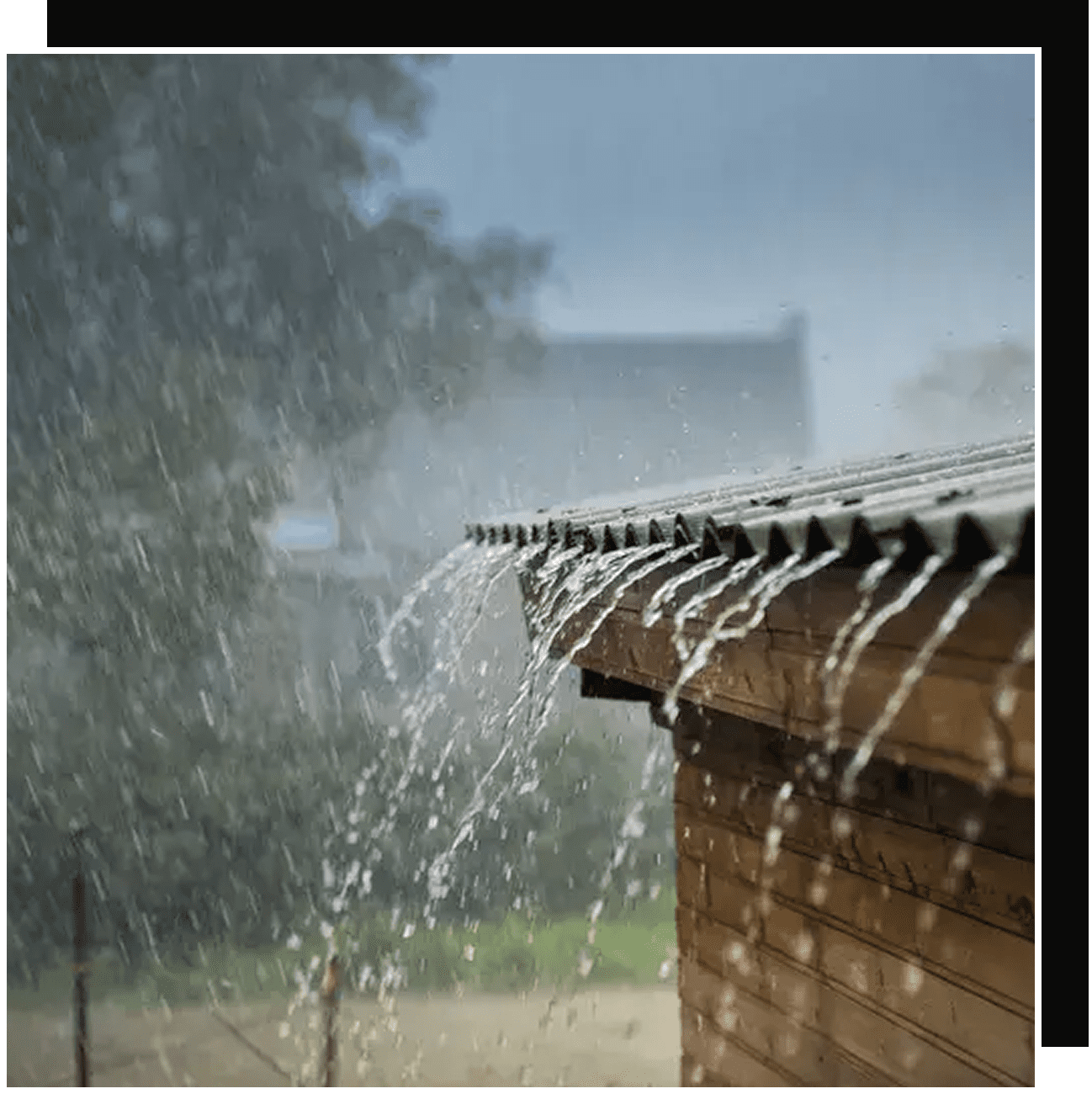 Heavy rain cascading off wooden shed roof