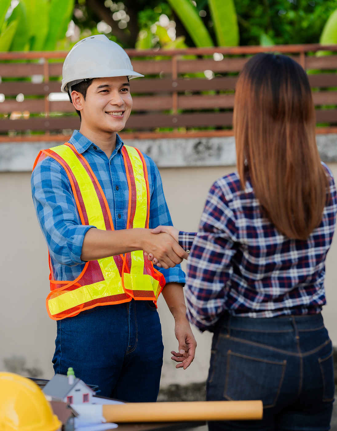 Smiling construction worker shaking hands with client