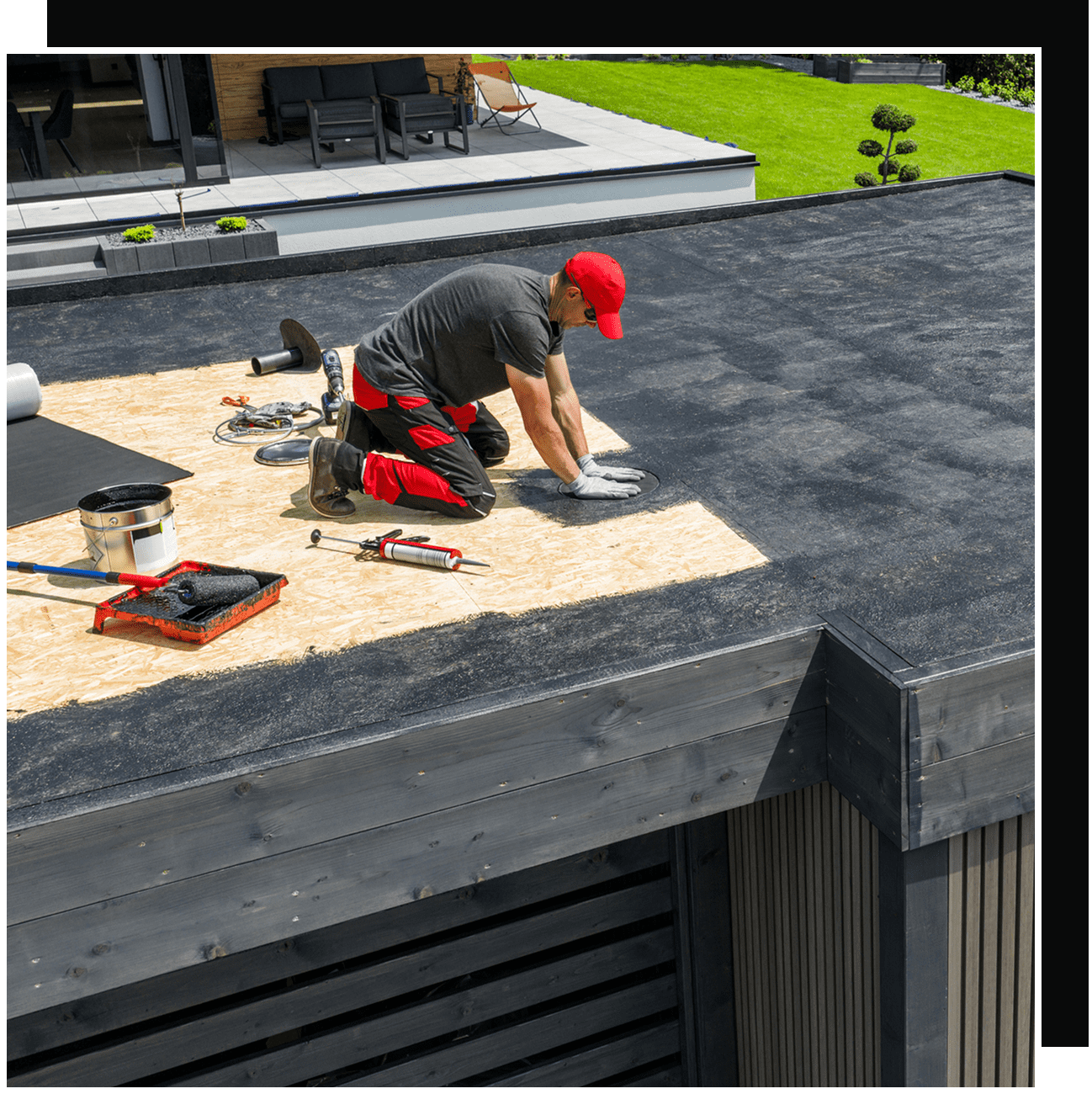 Roofer installing flat roof membrane on building