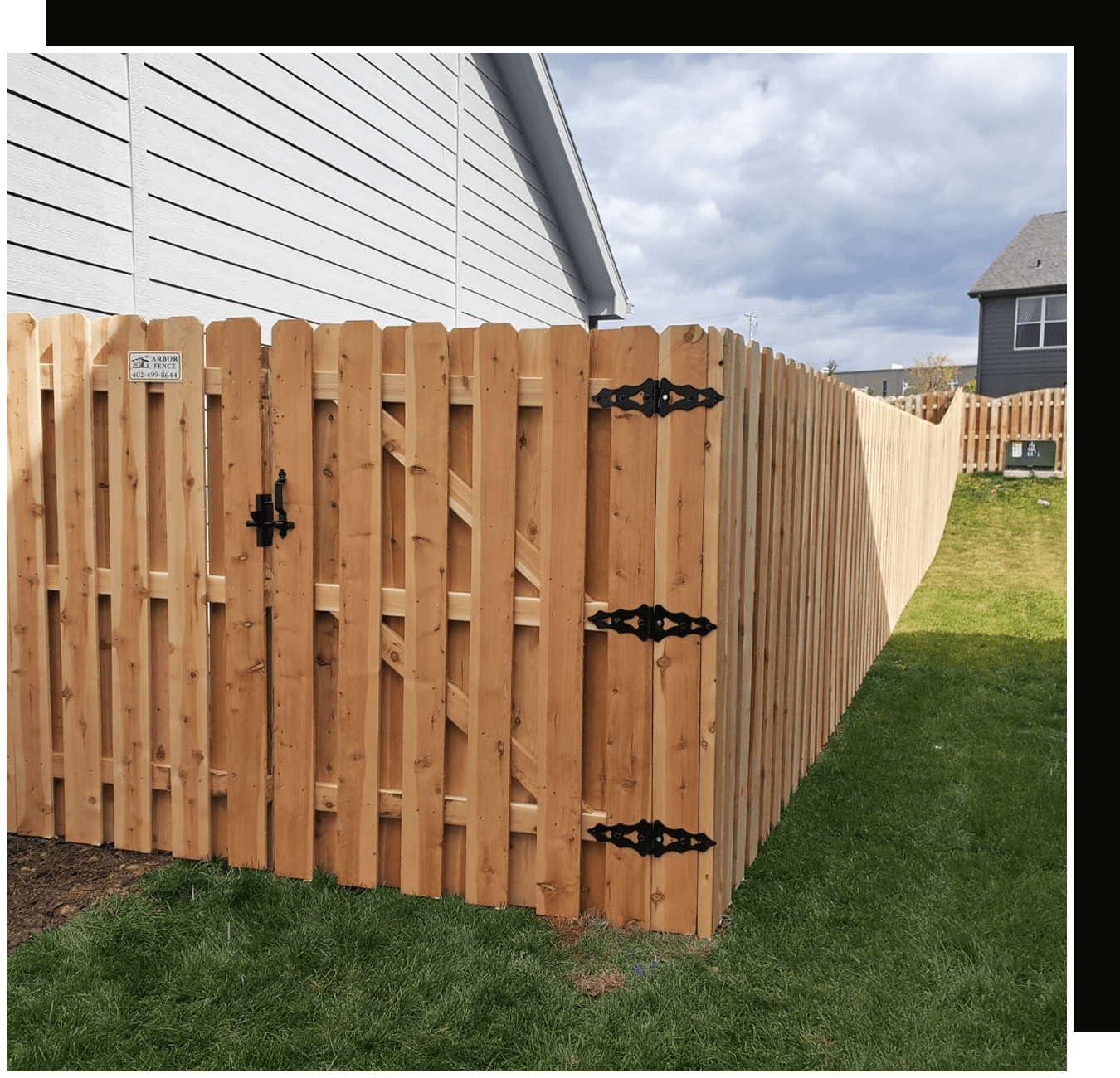 Wooden privacy fence with gate and black hinges