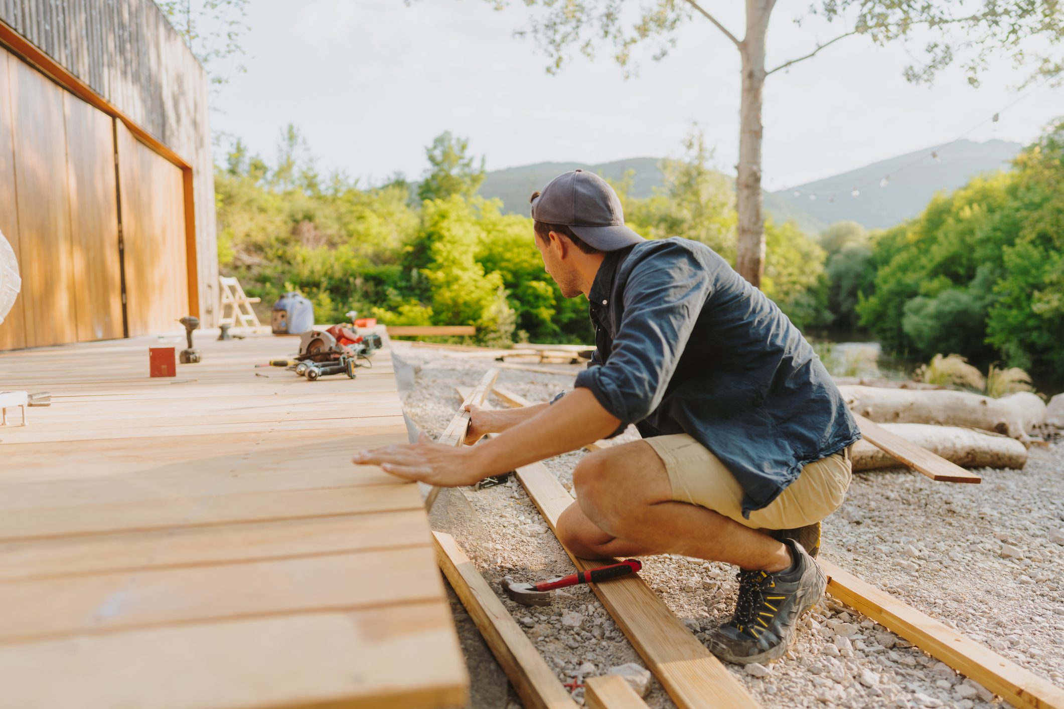 Worker installing wooden deck boards outdoors