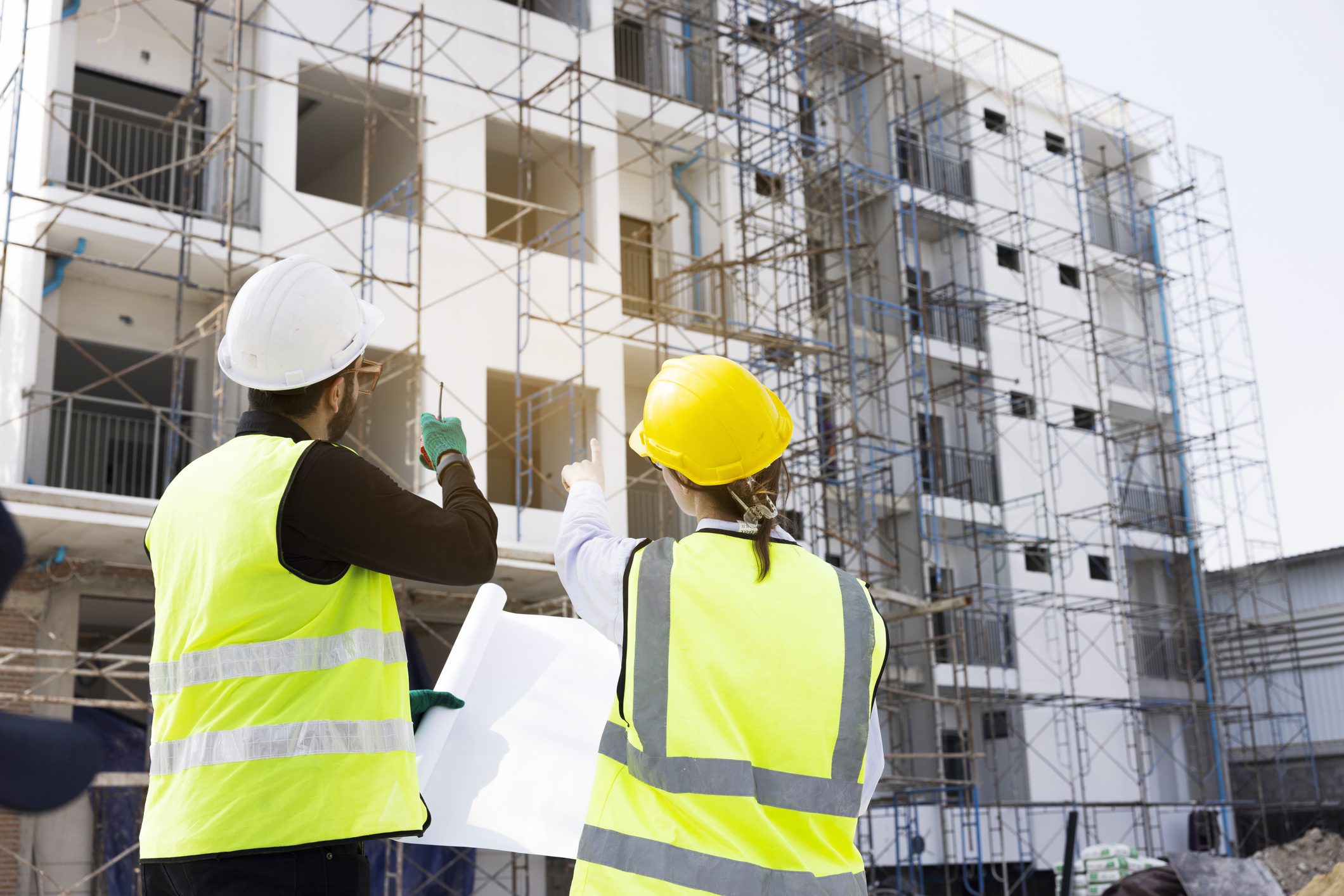 Two construction workers reviewing building plans
