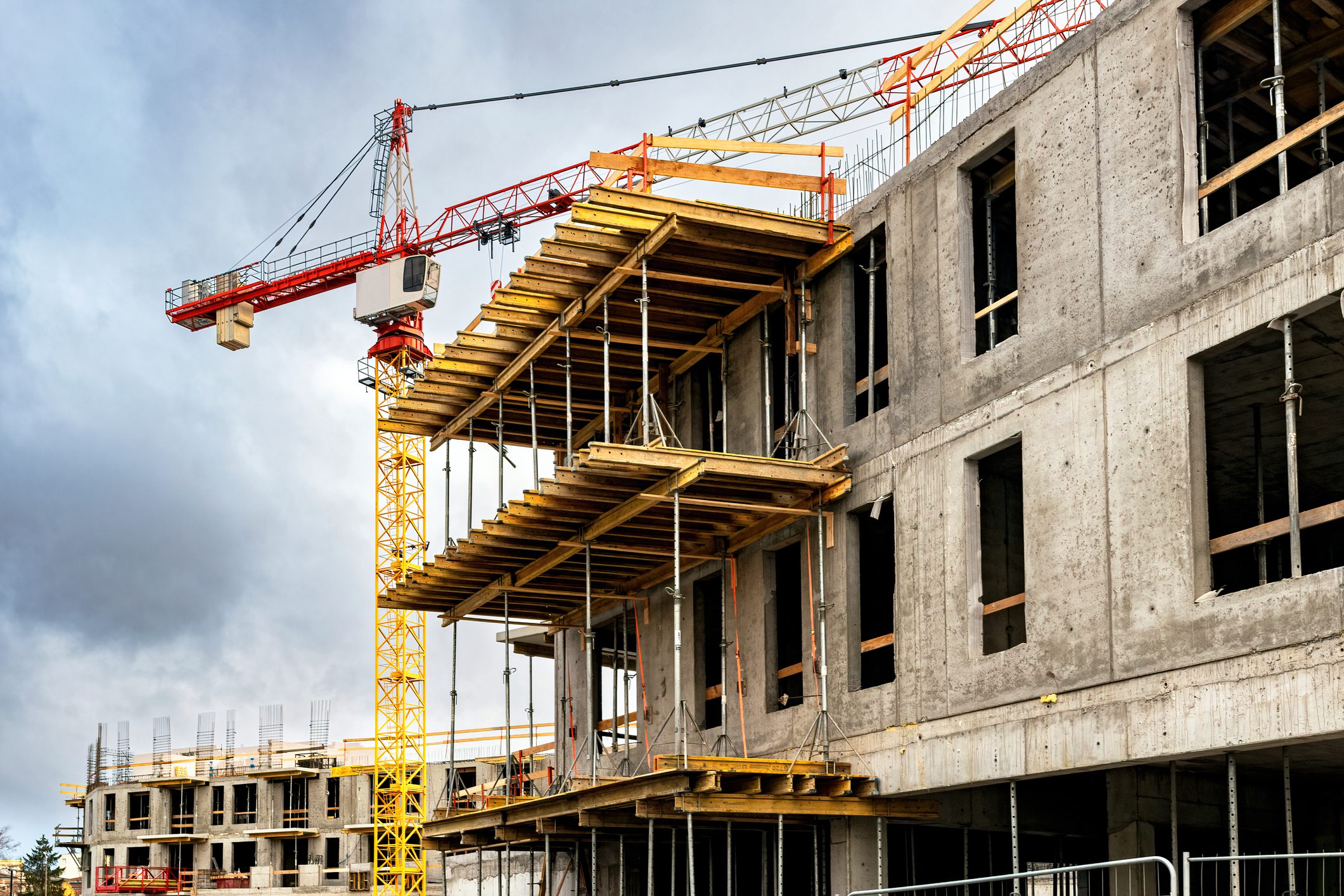 Concrete building under construction with tower crane