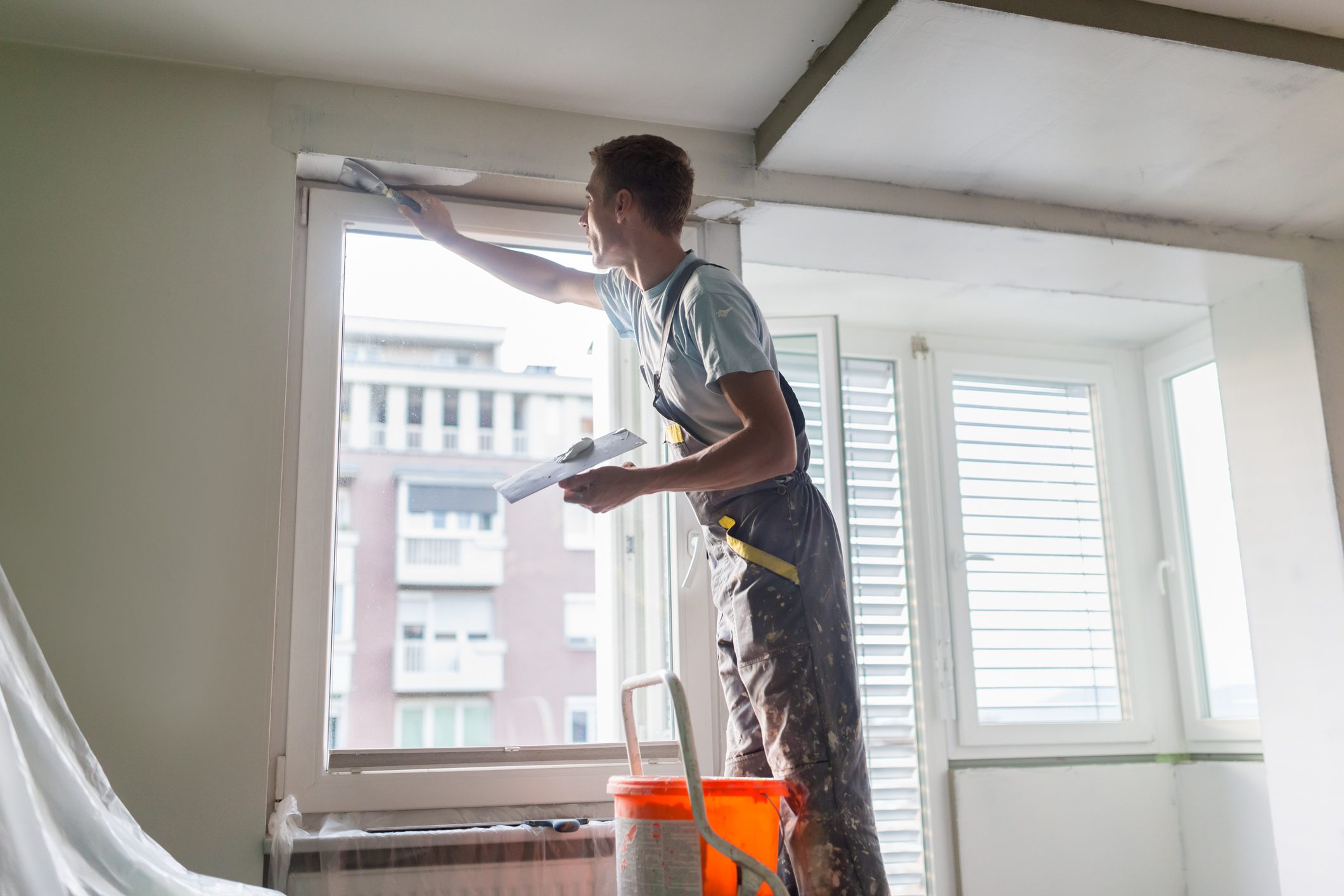 Person painting interior window frame