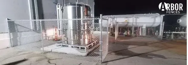 Industrial tanks secured by chain-link fence