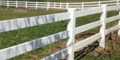 White fence along grassy field