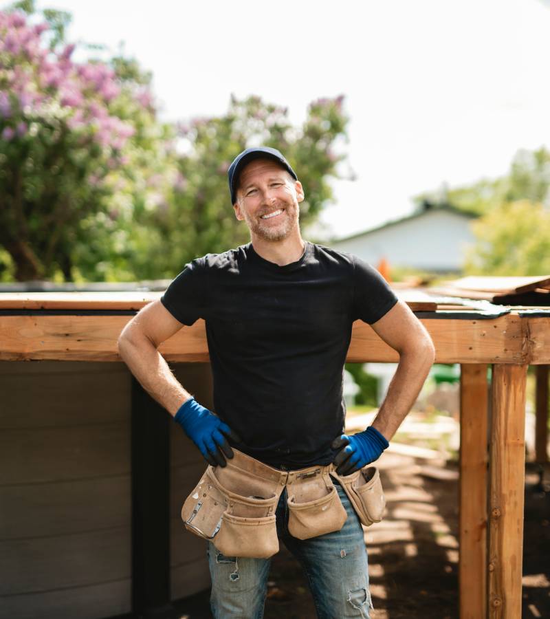 Smiling construction worker wearing tool belt