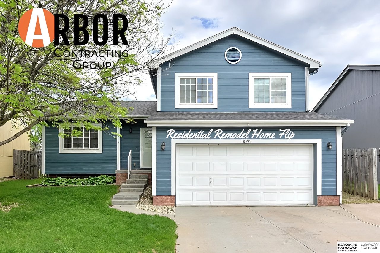 Blue remodeled house with garage and lawn
