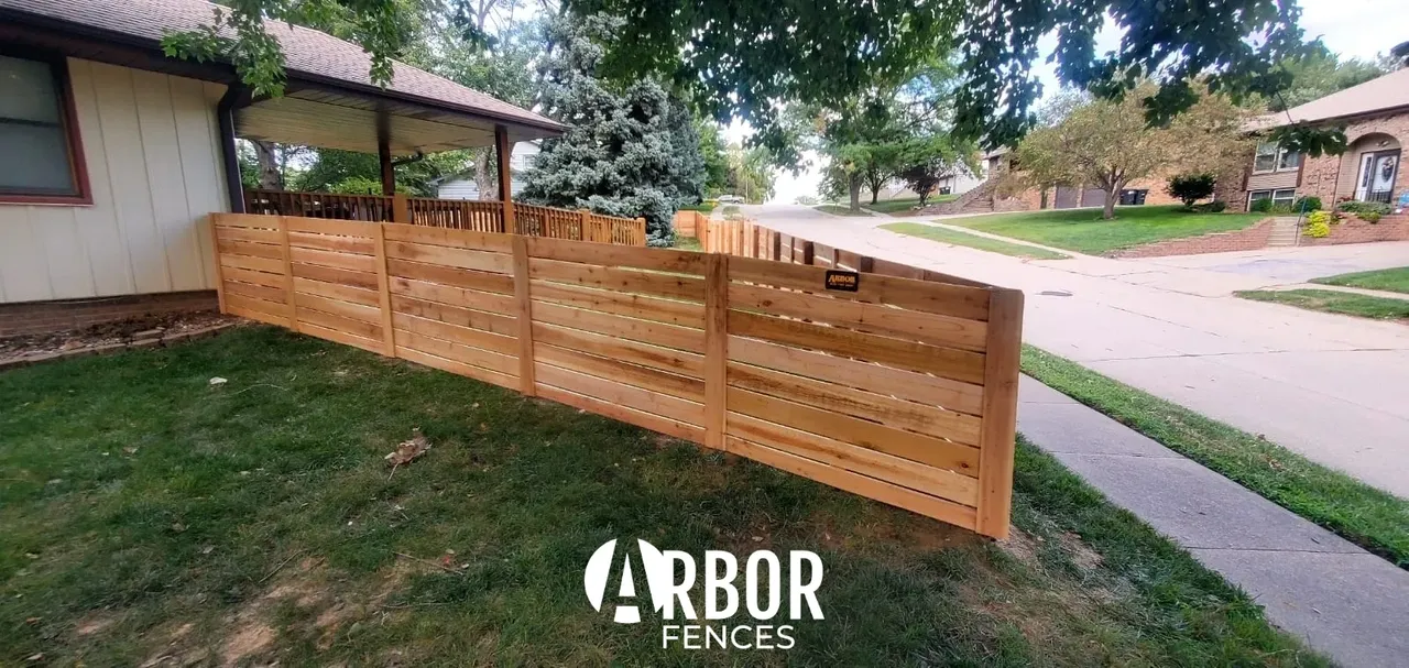 Horizontal wooden residential fence with Arbor logo