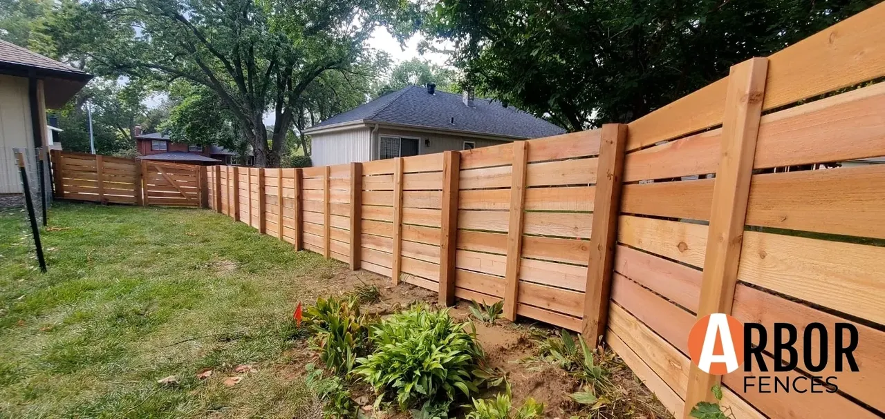 Horizontal wooden privacy fence in backyard