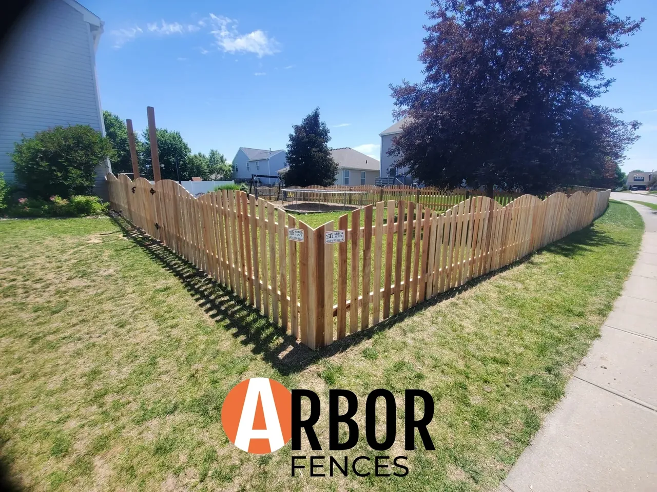 Wooden picket fence around yard, Arbor Fences logo