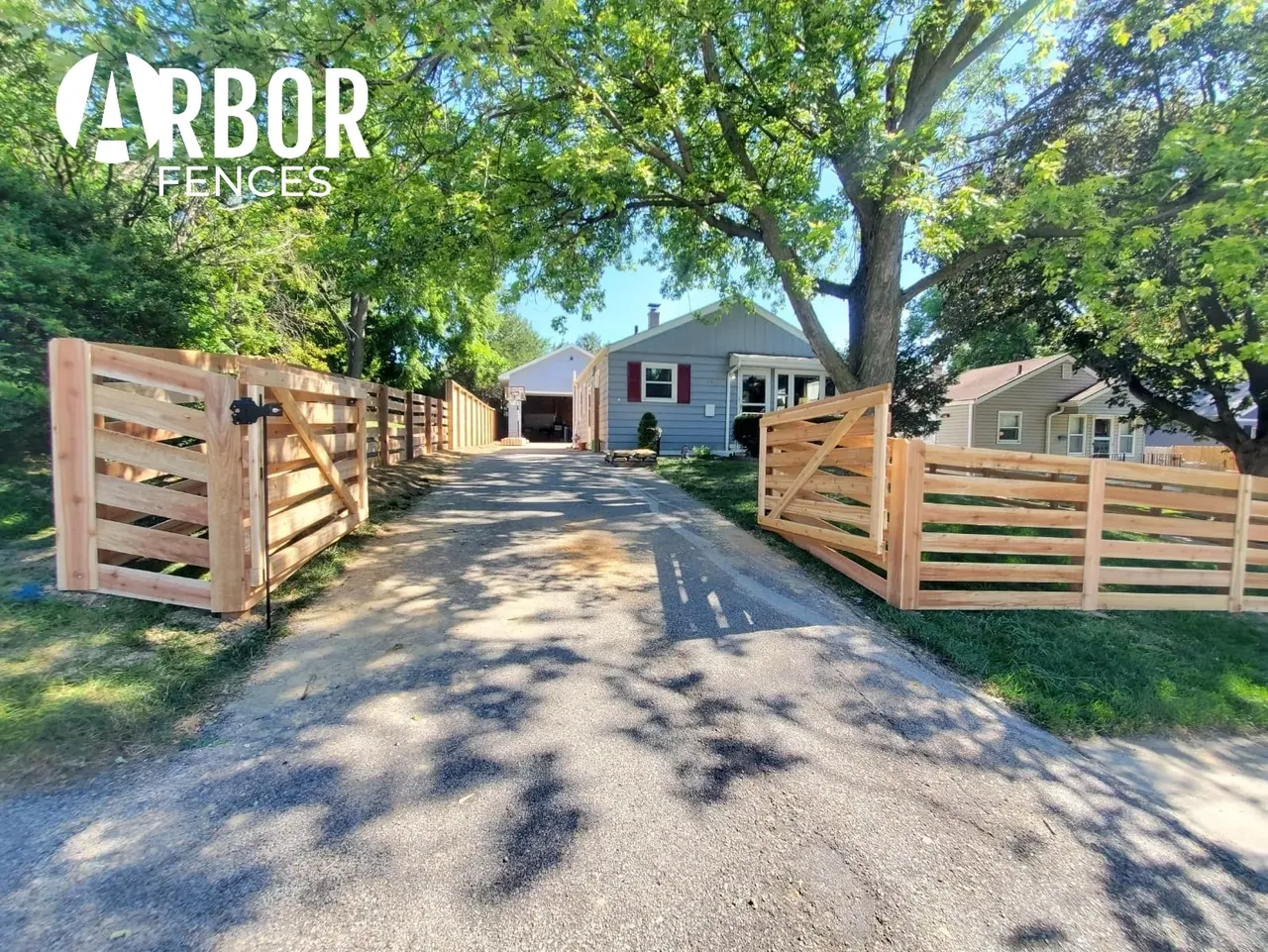 Open wooden driveway gates and slatted fence