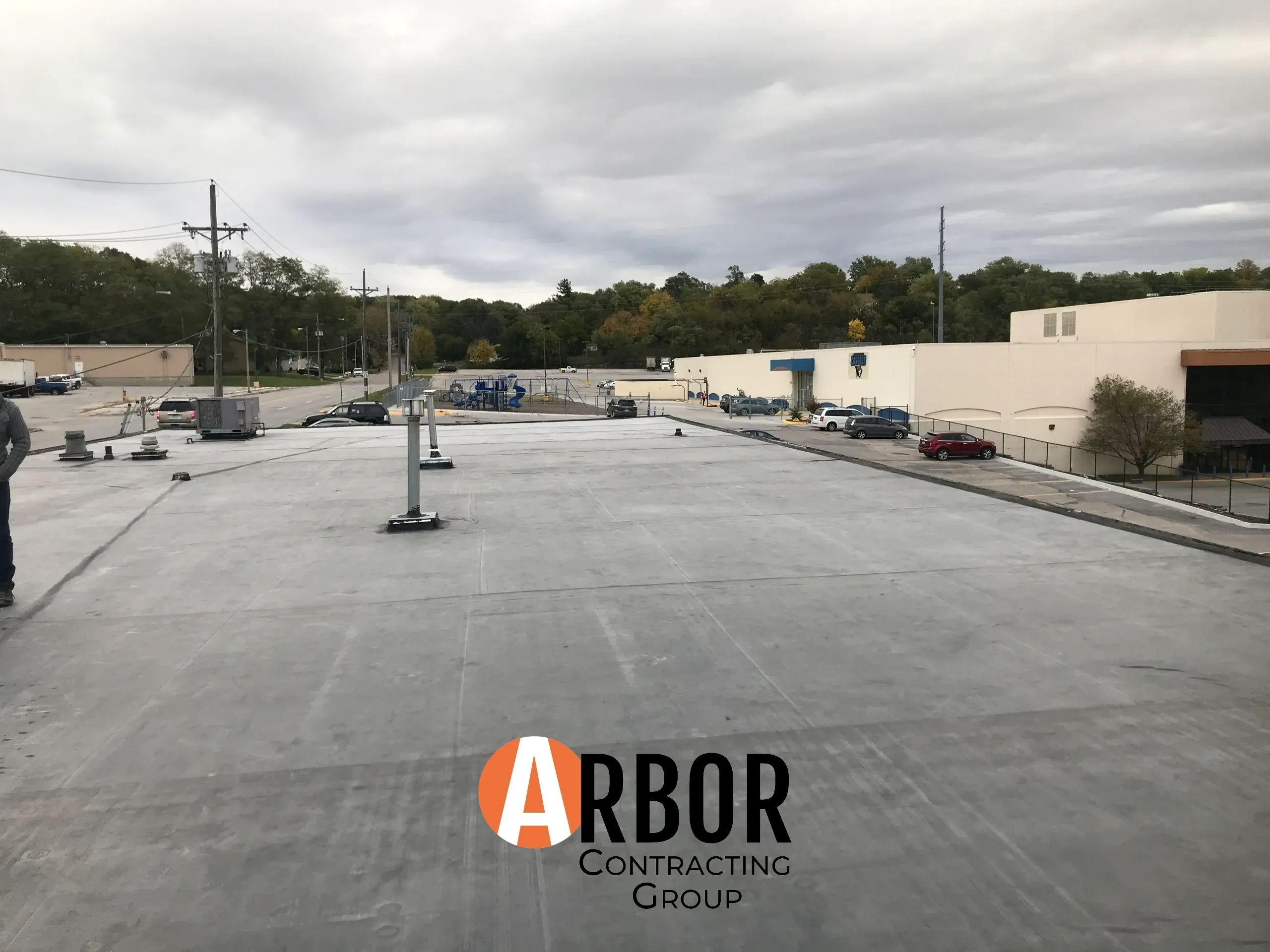Flat commercial roof with Arbor Contracting logo
