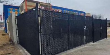 Black chain-link fence enclosing outdoor dining area