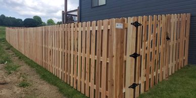 Cedar picket fence with gate by house