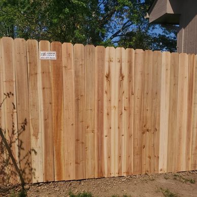 New cedar privacy fence with small sign