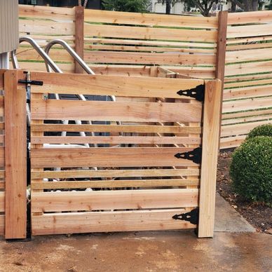 Slatted wooden pool gate with black hinges