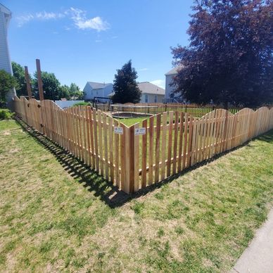 New wooden picket fence enclosing backyard