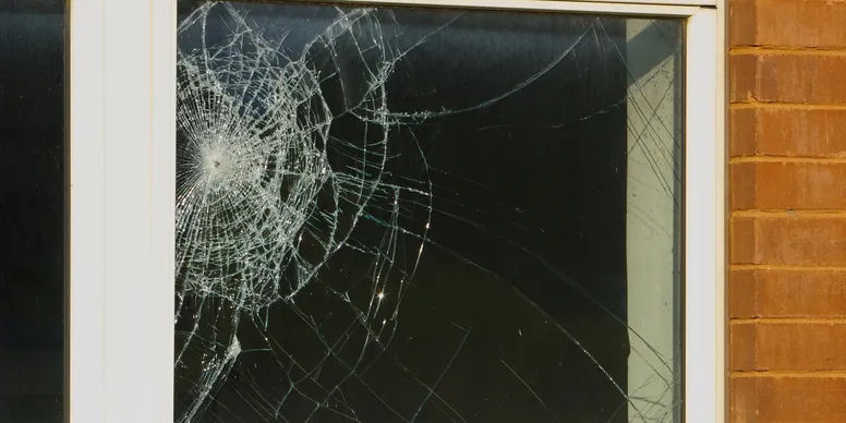 Window with spiderweb-patterned shattered glass