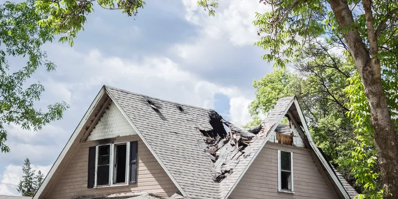 Damaged house roof with large collapsed section