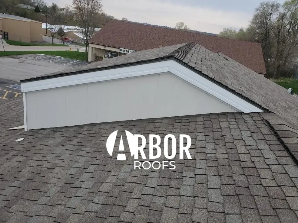 Shingled rooftop with Arbor Roofs logo