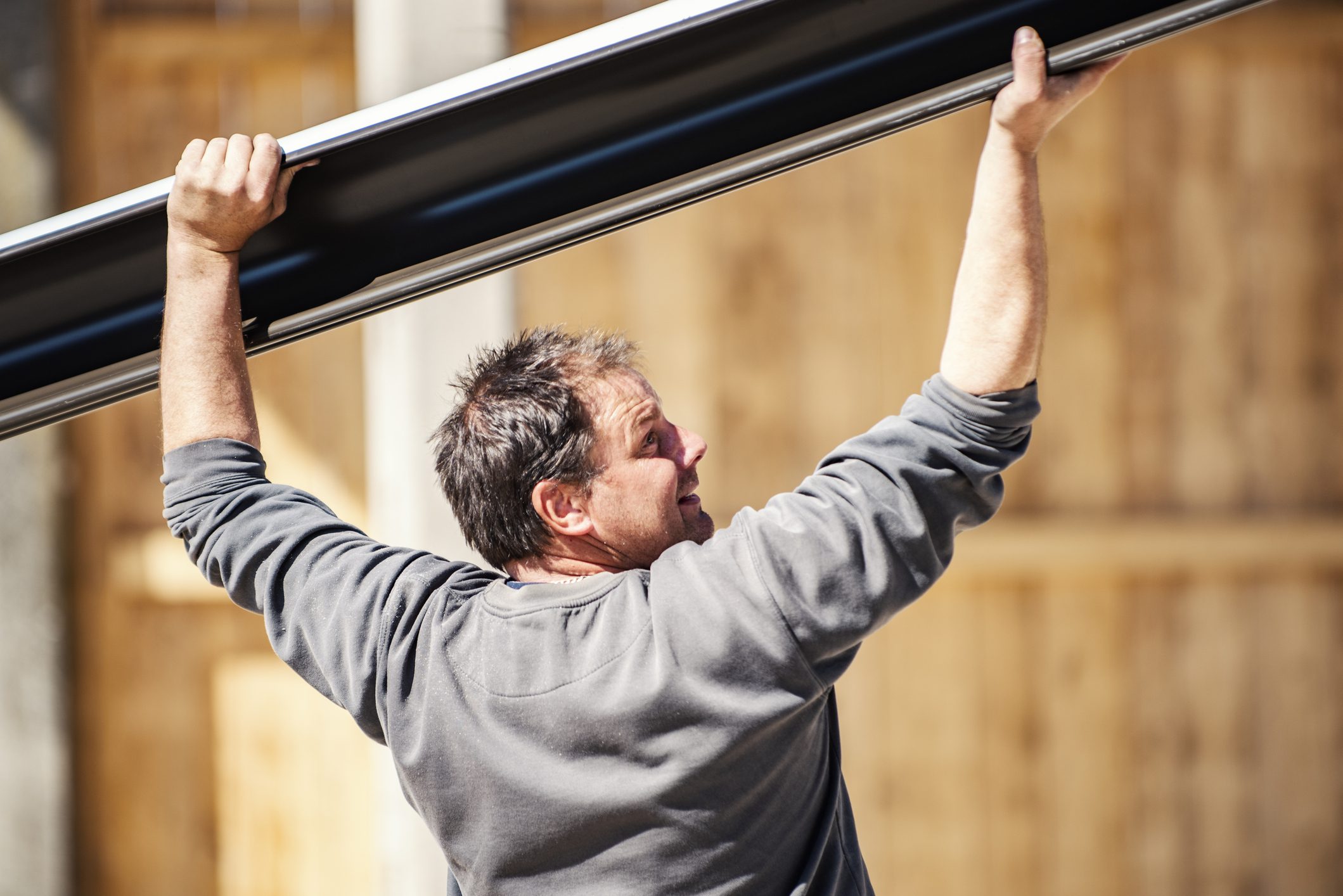 Manual worker installing gutter system on the roof