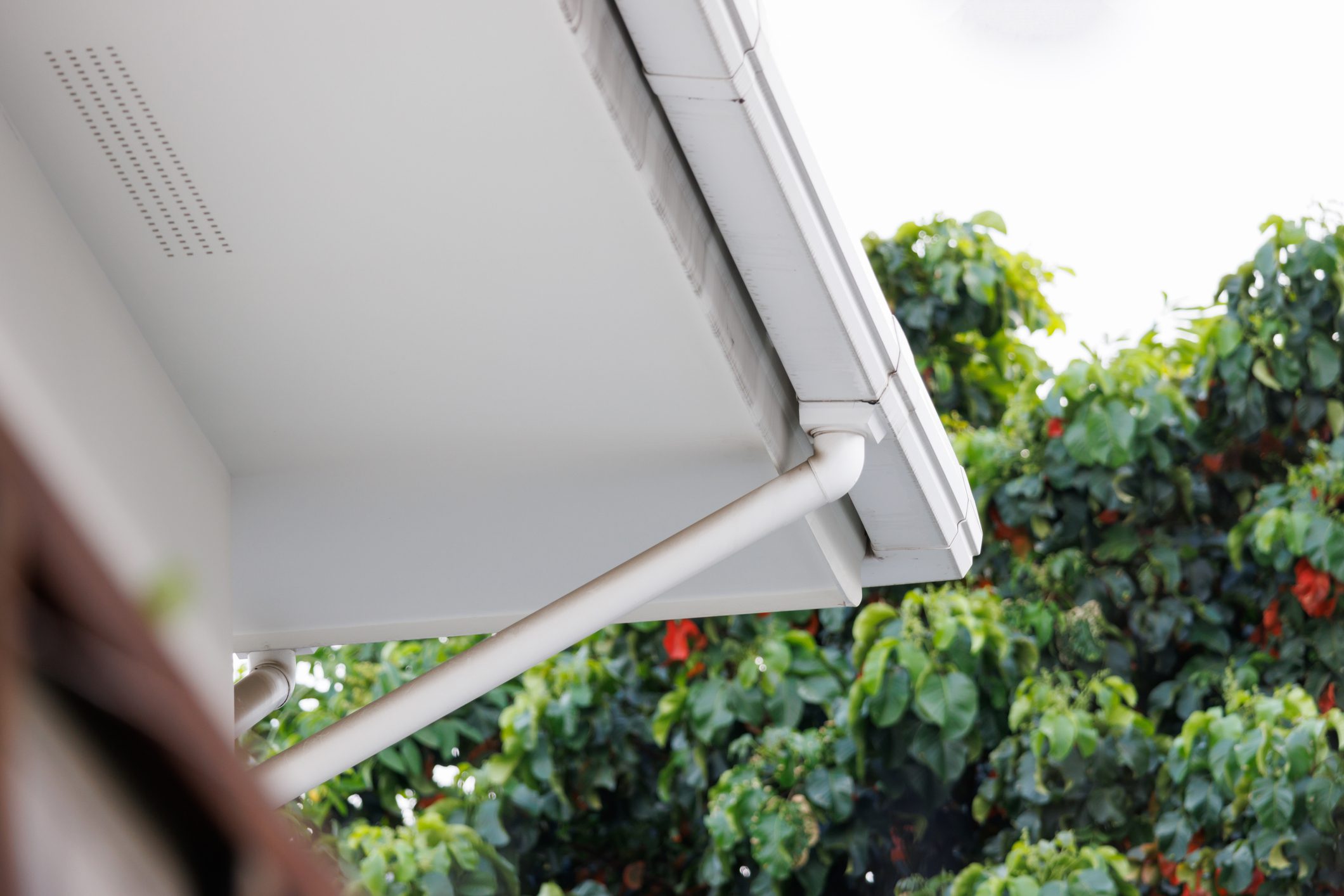white plastic rain gutter and the white sky. concept: preparing maintenance rain gutter before the rainy season.