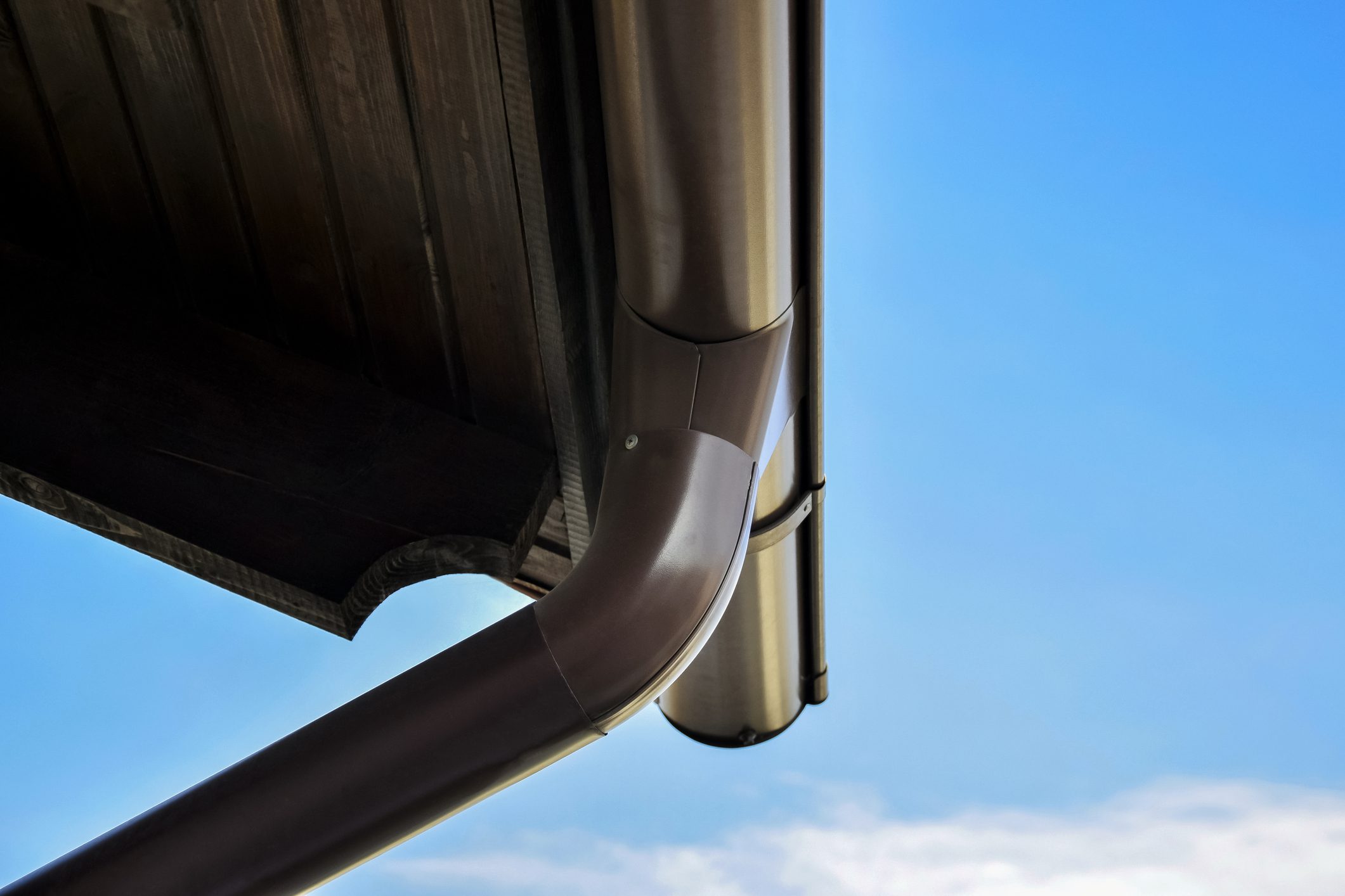 Part of the roof with pipes for draining rainwater. Bottom view against the blue sky. Close-up. Selective focus. Copy space.
