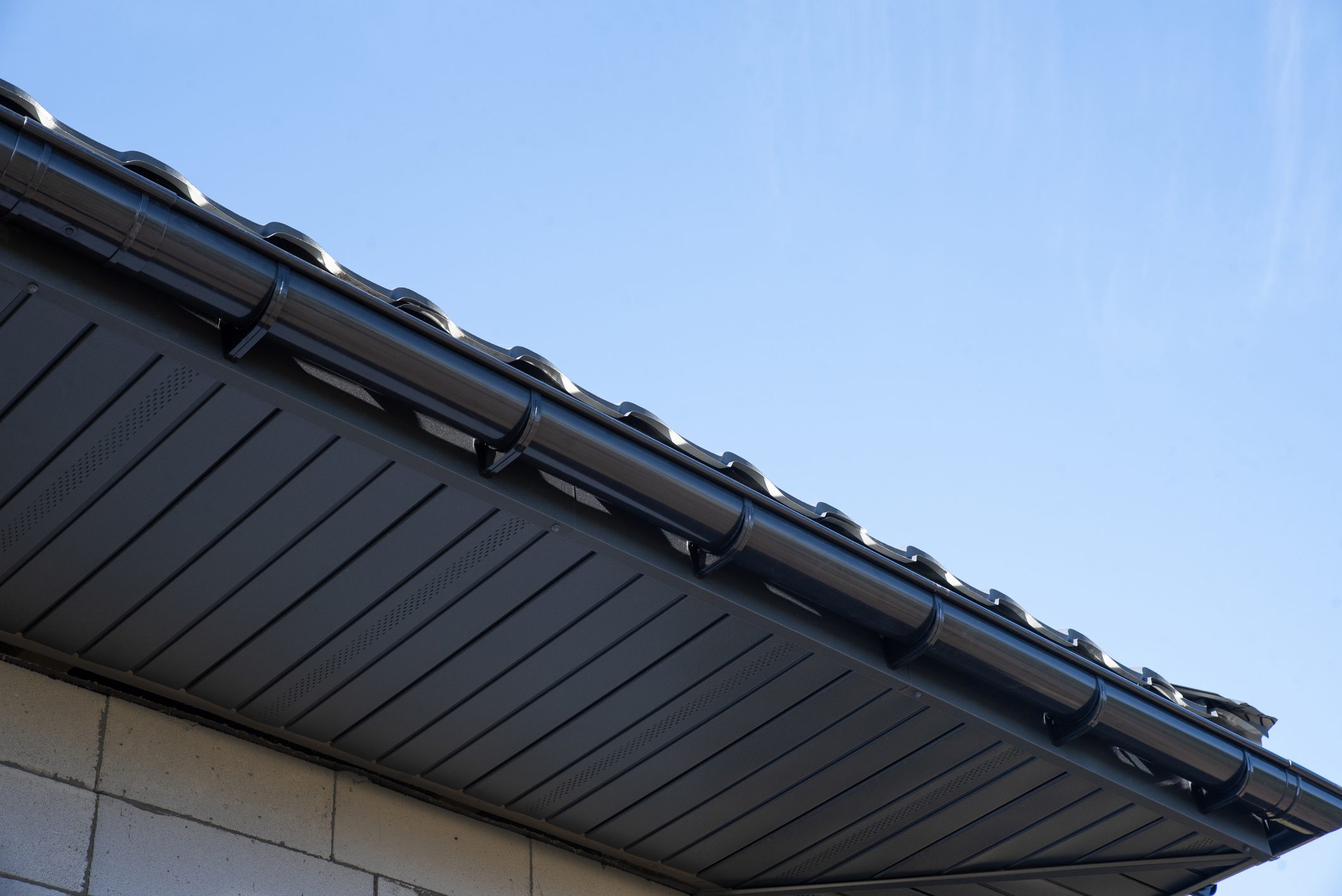 Metal soffit and gutters blend modern design with sky views, highlighting exceptional craftsmanship