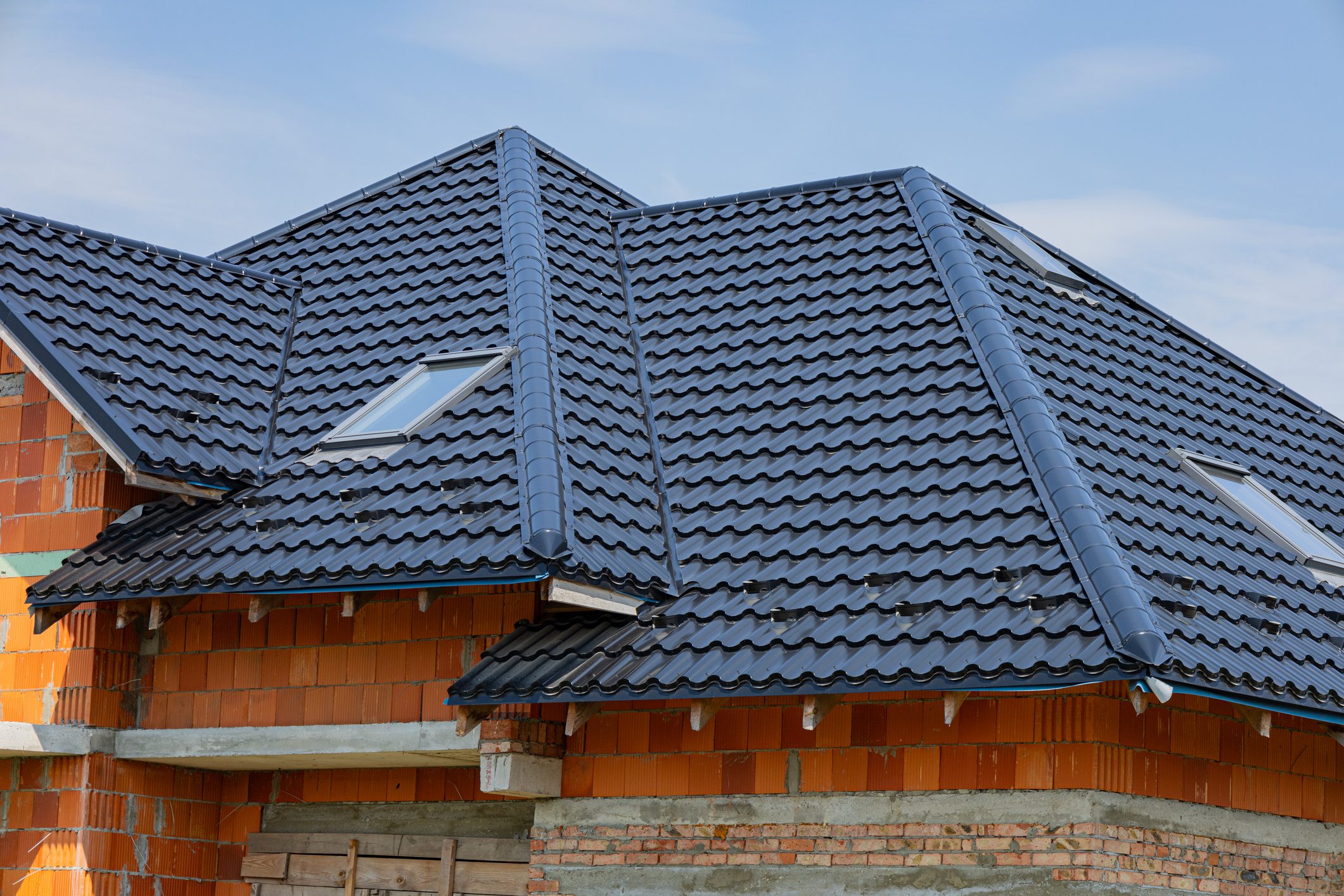 A recently completed metal roofing project highlights the durable tile design, enhancing the structure of a building under construction.