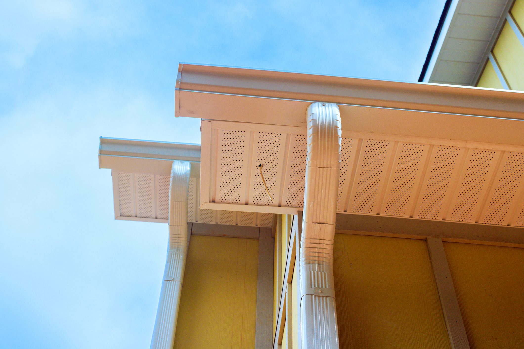 Roofs of house with edges gutters details yellow panel Hardie siding walls