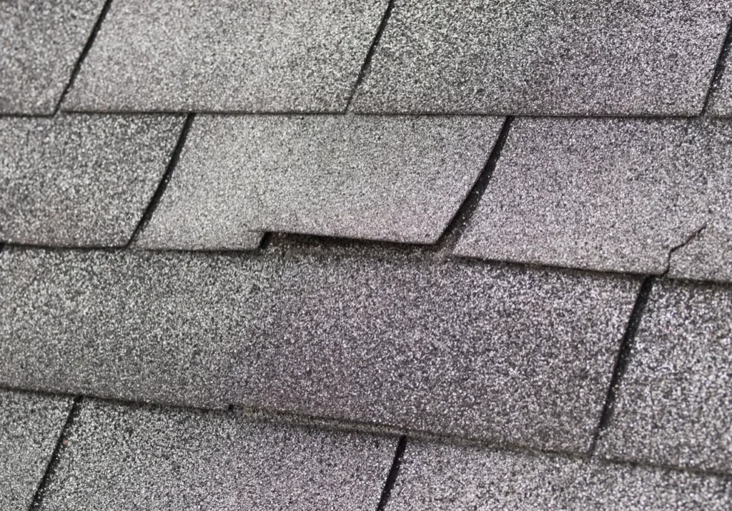 Close-up of damaged asphalt roof shingles